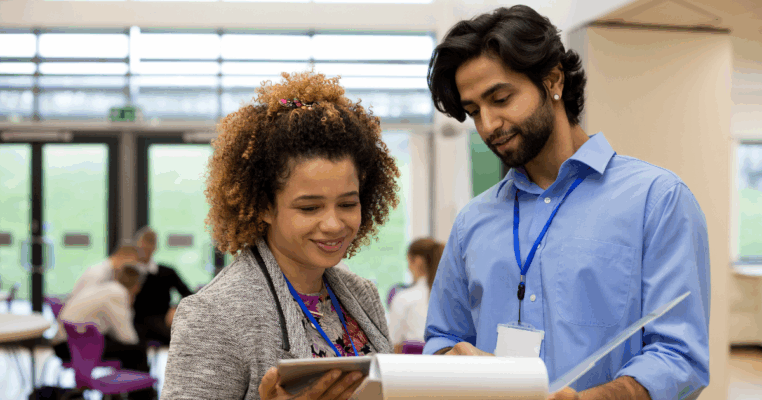 Two professional educators reviewing documents