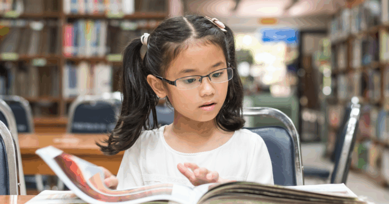 young girl looking at book