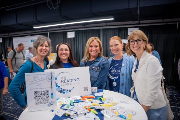 TRL conference attendees group photo smiling at table with TRL swag