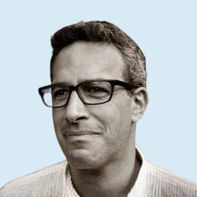 Adrian Staub headshot with blue background