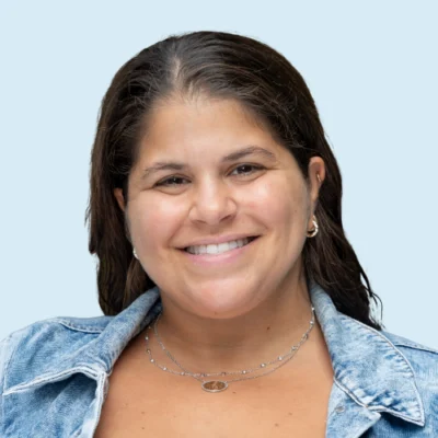 Aviva Coyne Green headshot with blue background