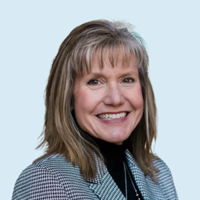 Kelly Powell Smith headshot with blue background