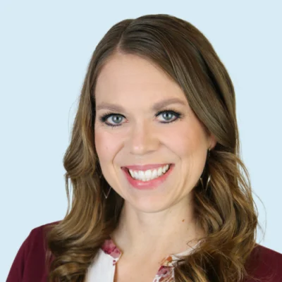 Lindsey Kemeny headshot with blue background