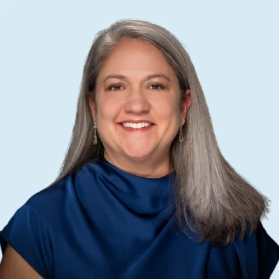 Marisa Ramirez Stukey headshot with blue background