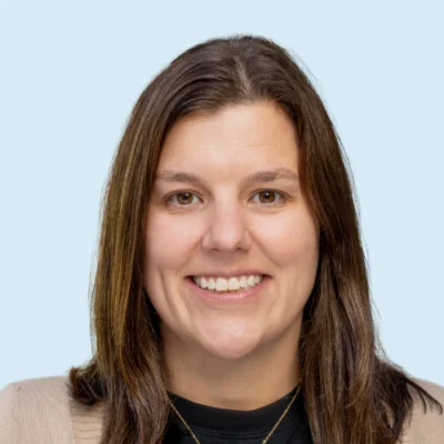 Tina Zampitella headshot with blue background