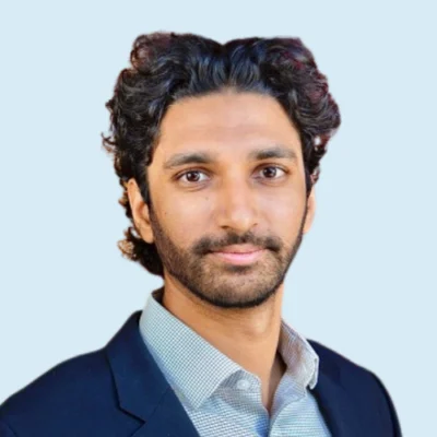 Vivek Ramakrishnan headshot with blue background