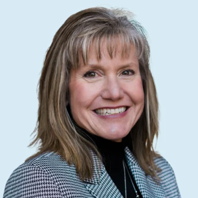 Kelly Powell-Smith headshot with blue background